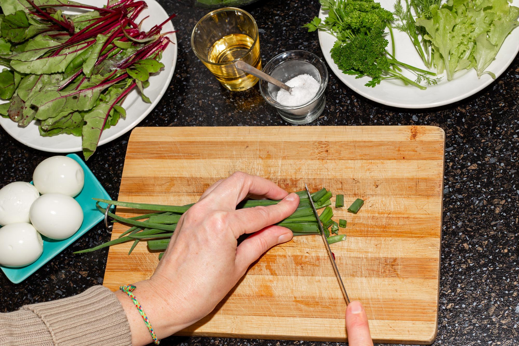 Hand-cut herbs over wooden board